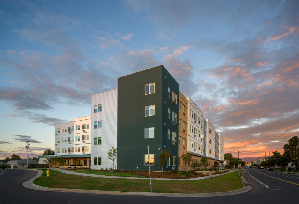 Modern building at sunset with colorful sky, corner street view