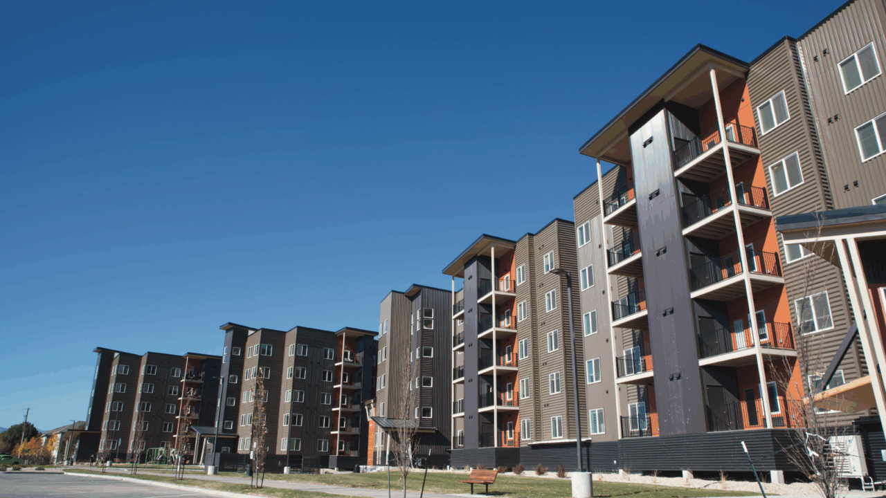 Modern apartment buildings under clear blue sky, wide-angle perspective