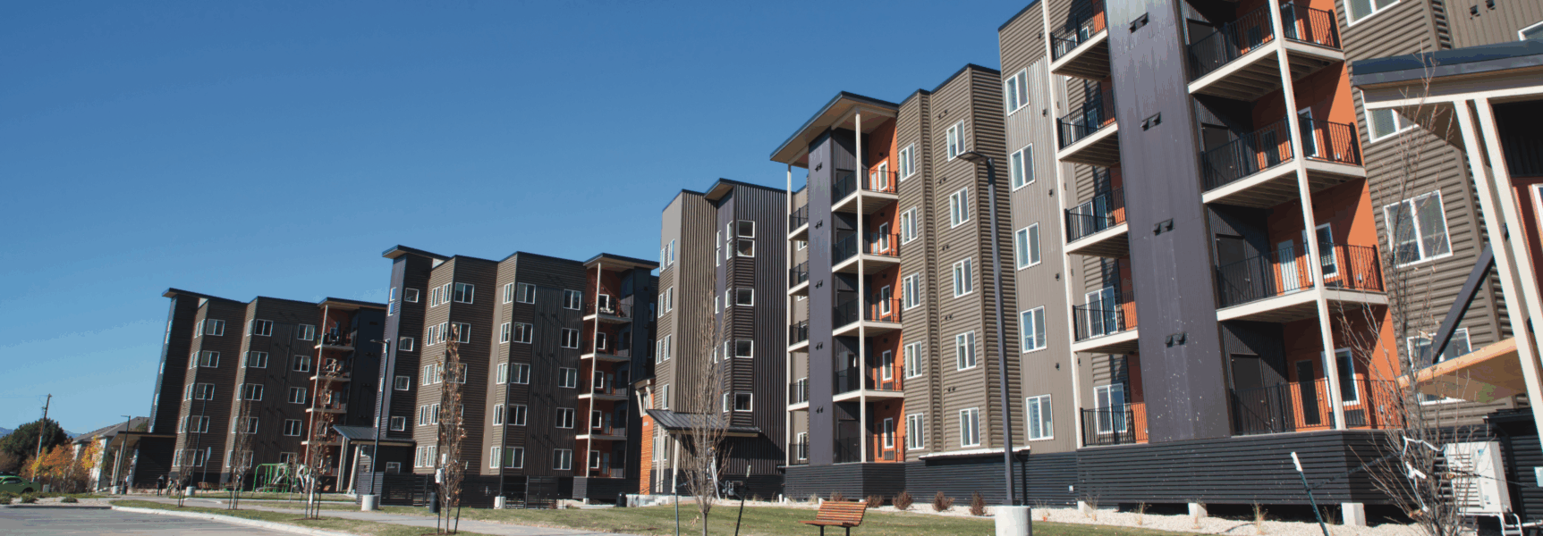 Modern multi-story apartment buildings under clear blue sky
