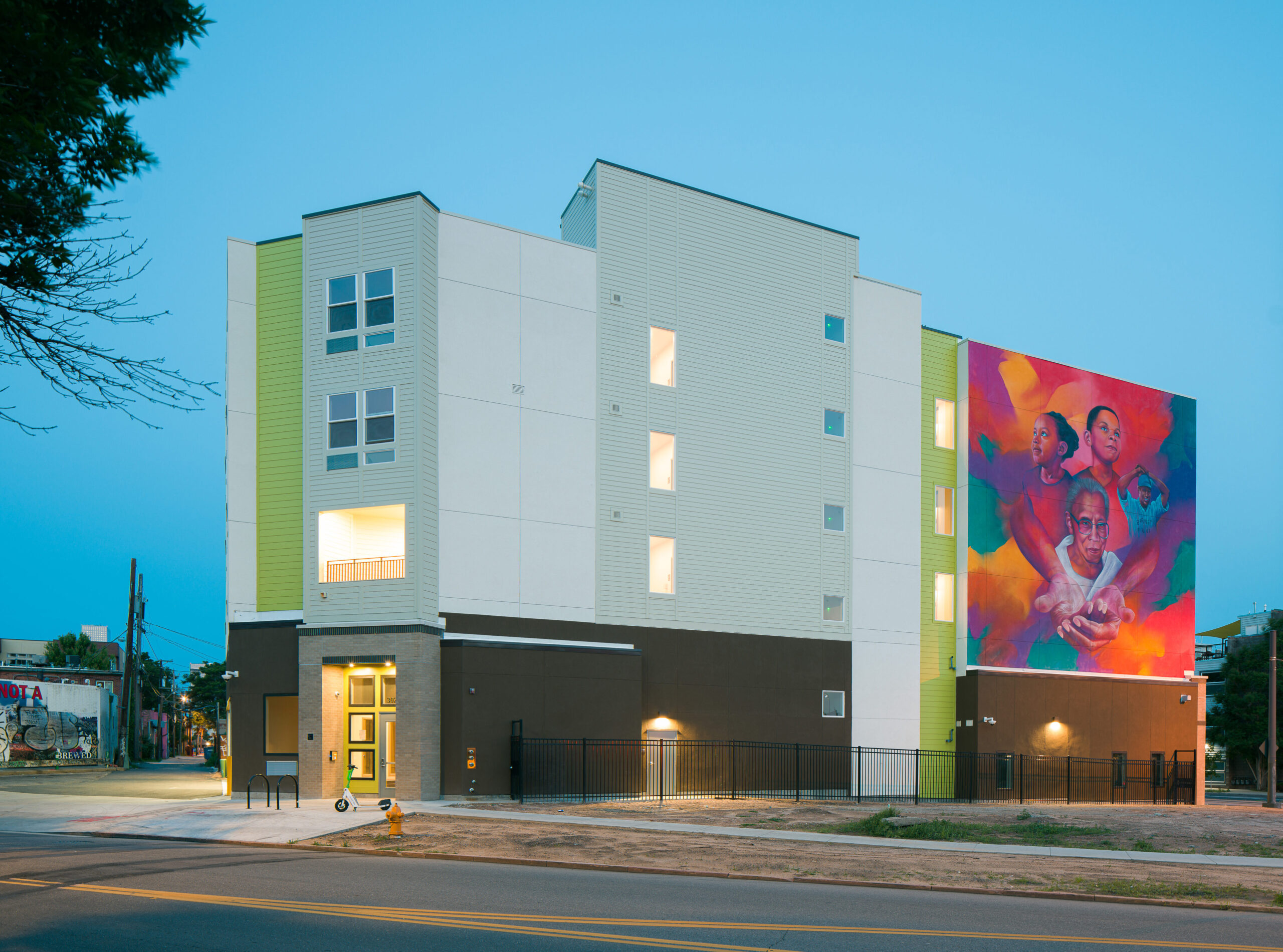 Charity's House exterior; colorful mural of embracing figures.