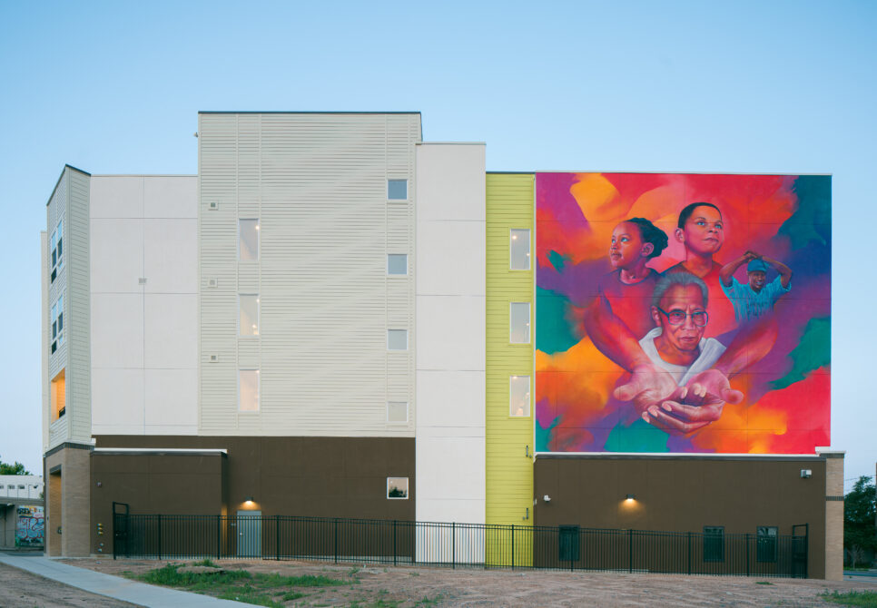 Charity's House exterior with vibrant mural depicting people in colorful background