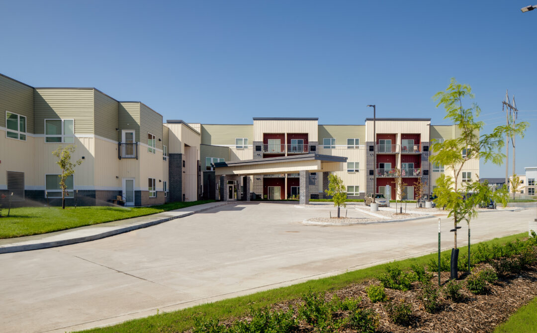Elliott_exterior-9-scaled-aspect-ratio-0-670.jpg showing a modern building with a wide driveway and landscaped entrance