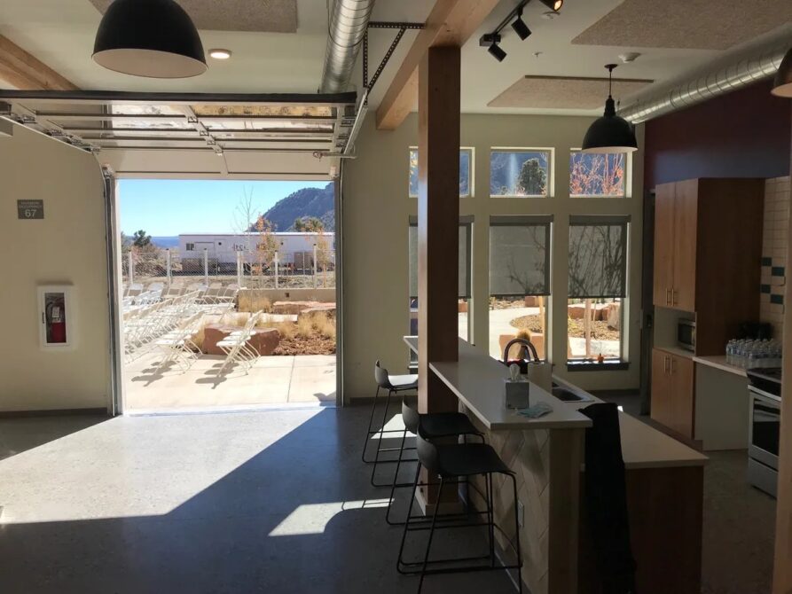 Open garage door revealing outdoor seating area with mountain view