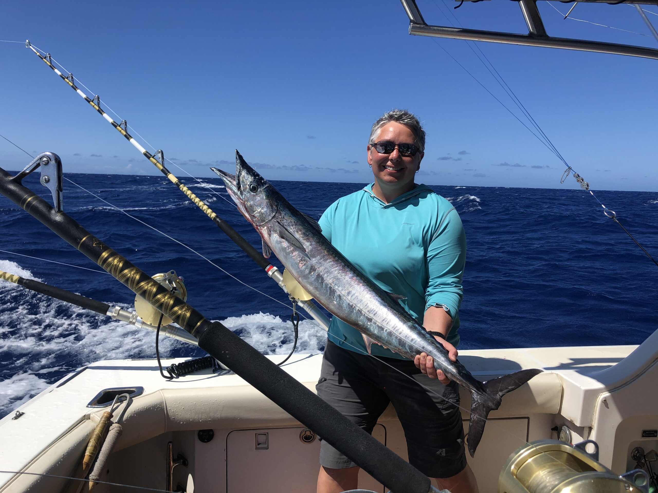 Gabby holding a large fish on a boat in the ocean