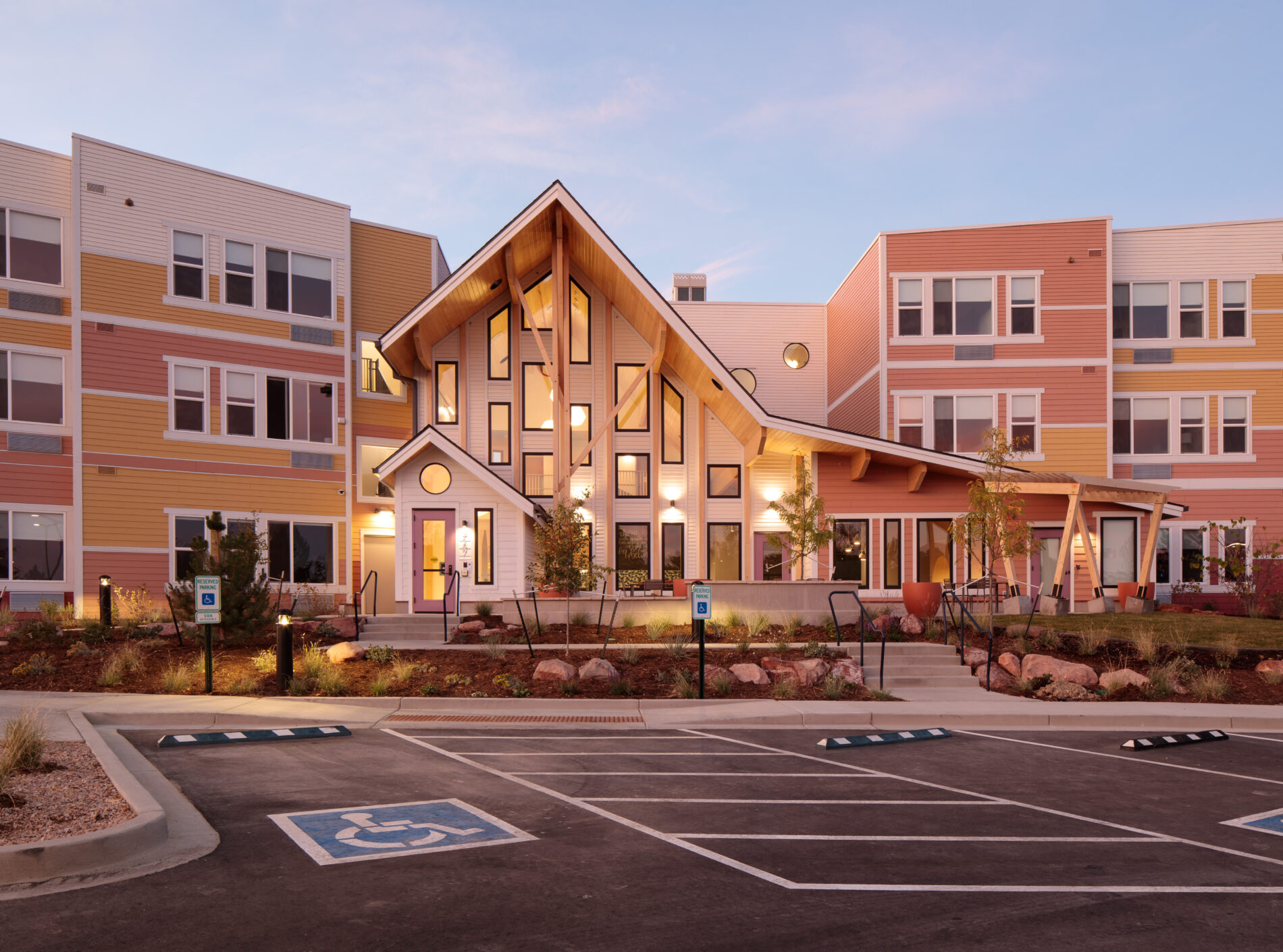 Laurel House exterior with colorful siding, modern design, and accessible parking at sunset.