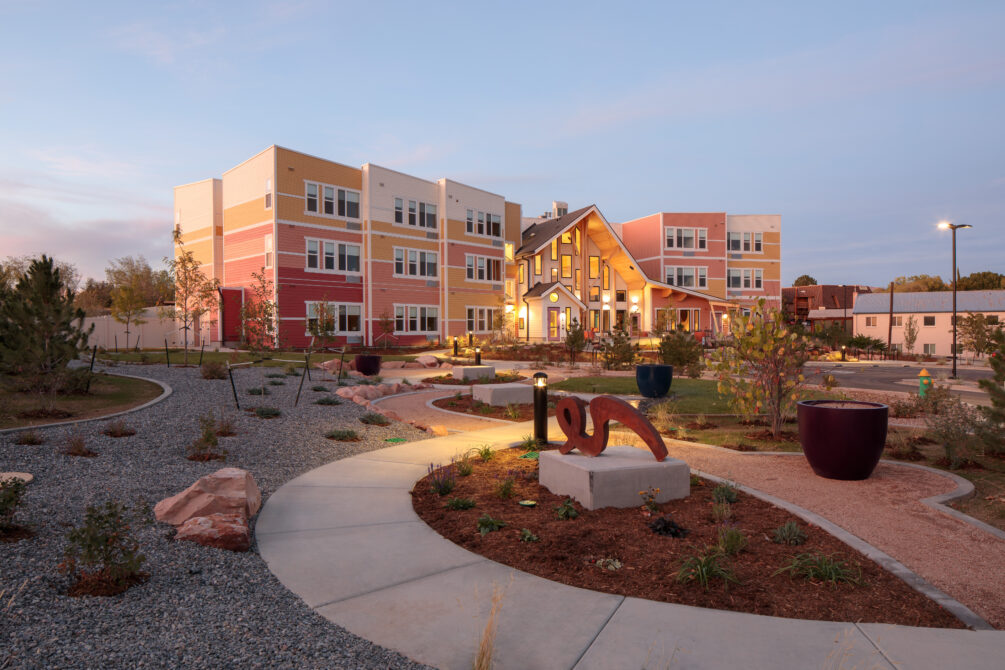 Laurel House exterior with vibrant colors, landscaped paths, twilight setting