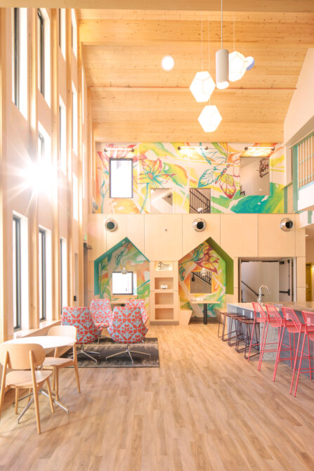 Bright, open interior with colorful murals, modern furniture, and high ceilings.