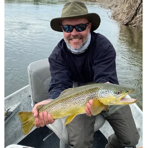 Nate holding a large fish on a boat, smiling broadly