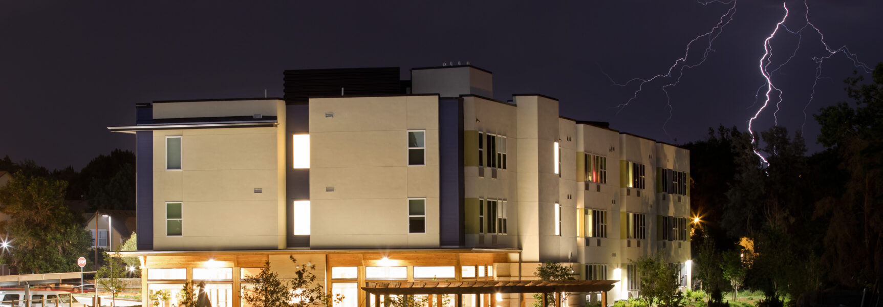 Modern building illuminated at night with lightning in the background
