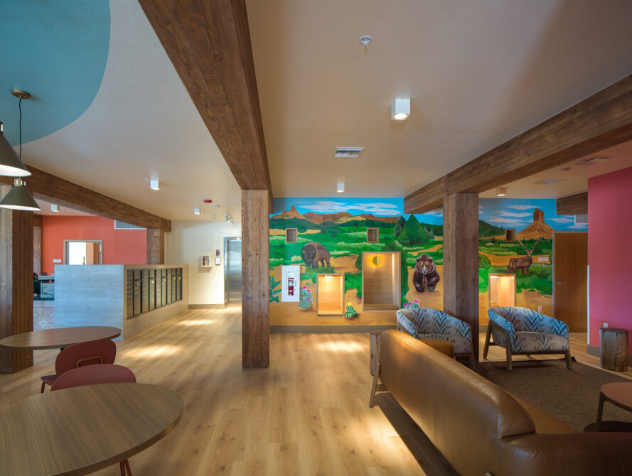 Colorful mural with bison, mountains in modern lounge with wooden beams and seating