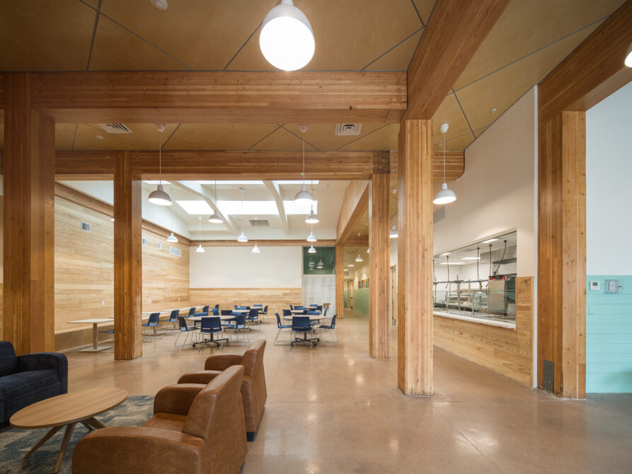 Spacious community dining area with wooden columns and modern lighting.