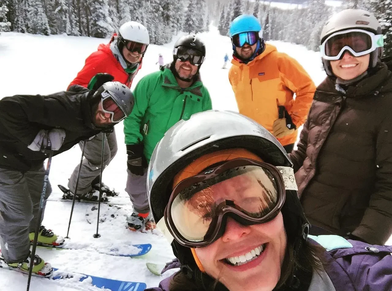 Group of six smiling skiers posing on snowy slope