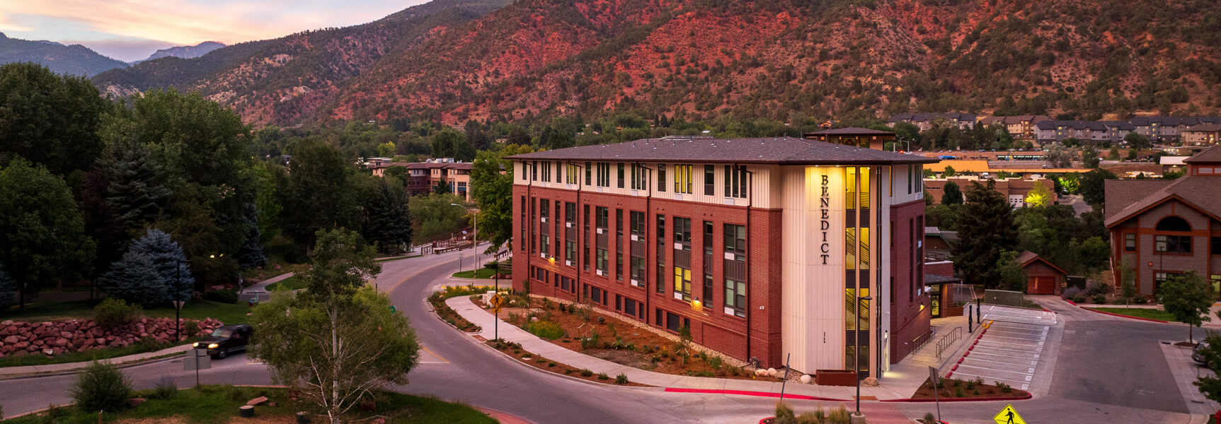 Benedict building with sunset view, surrounded by trees and mountains