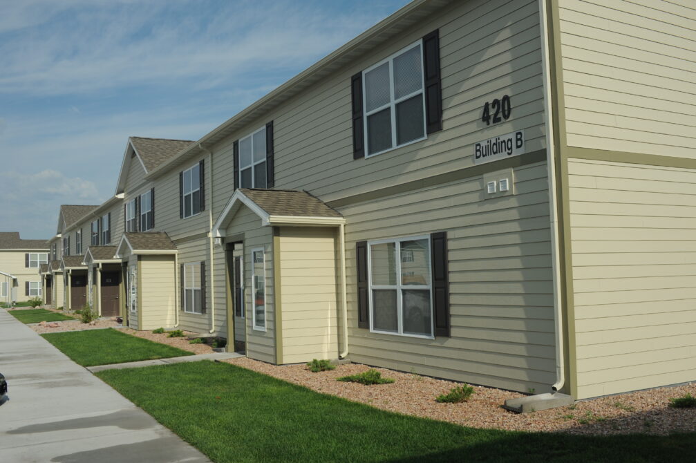 Building B with beige siding, labeled "420," along a landscaped path.