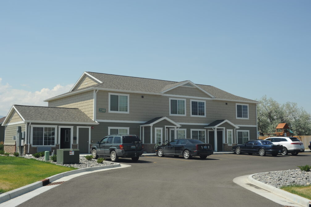 Two-story beige apartment building with cars parked in front, numbered 2289