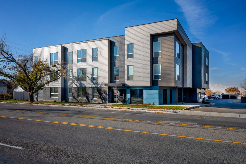 Modern three-story office building with large windows and clean lines on a clear day