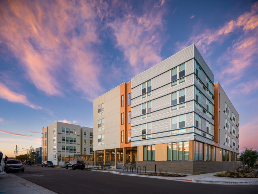 ResidencesOnAcoma_FirstLook_001.jpg shows modern apartment buildings under a colorful sunset sky.