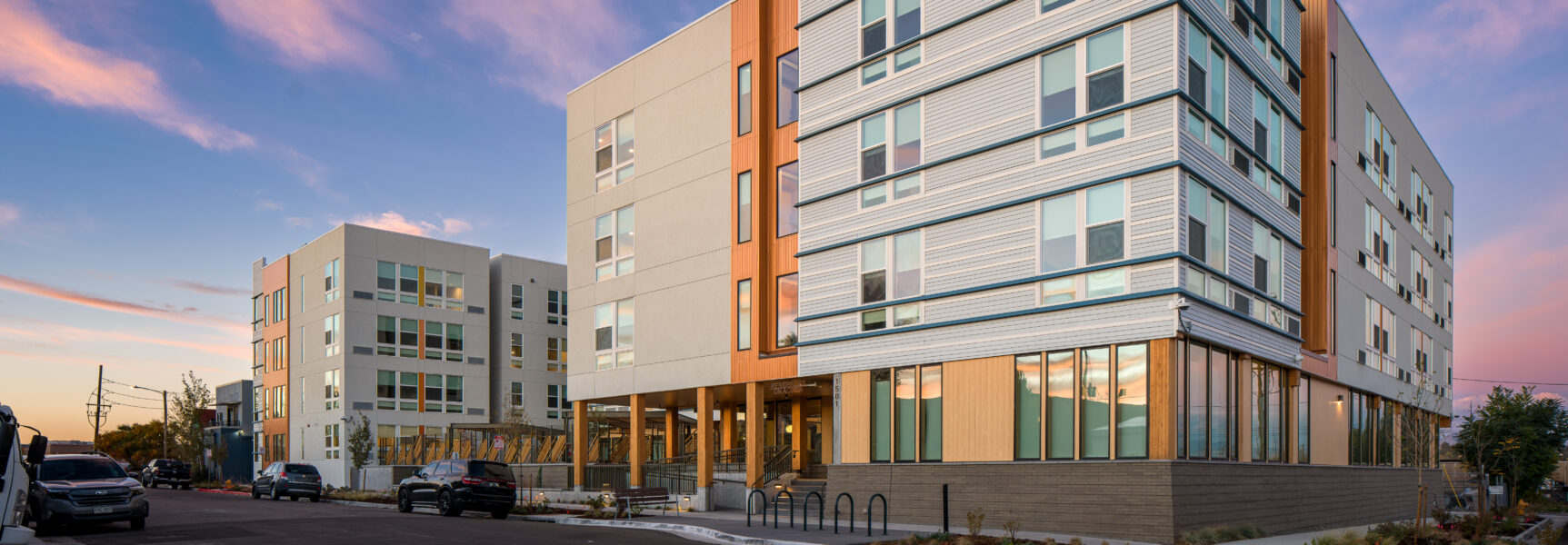 ResidencesOnAcoma_FirstLook_001.jpg shows modern apartment buildings under a colorful sunset sky.