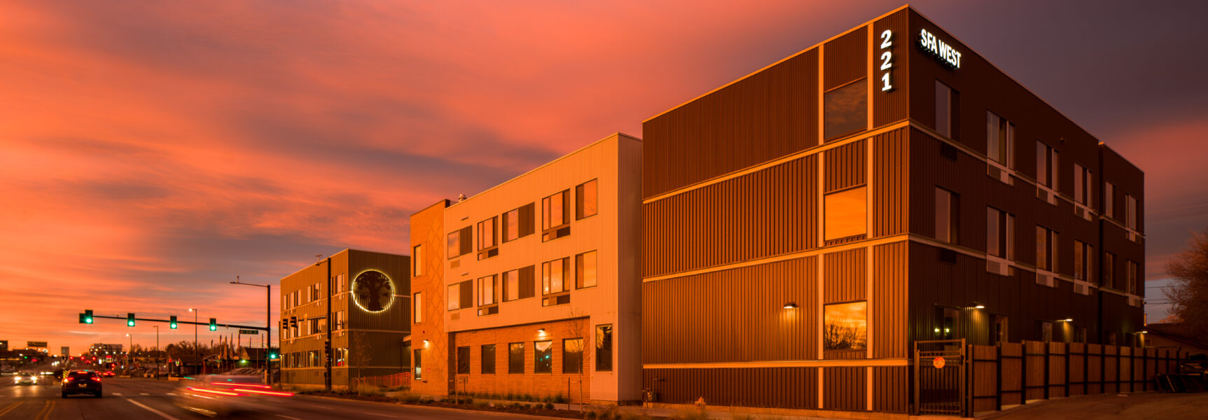 St. Francis Apartments West exterior at sunset, 221 SFA WEST sign, vibrant sky.